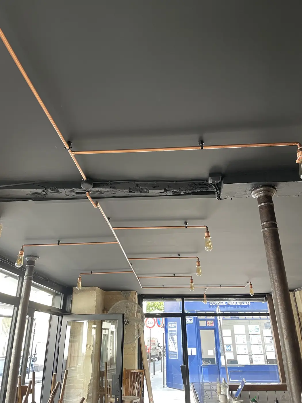Plafond noir et réseau cuivre apparent