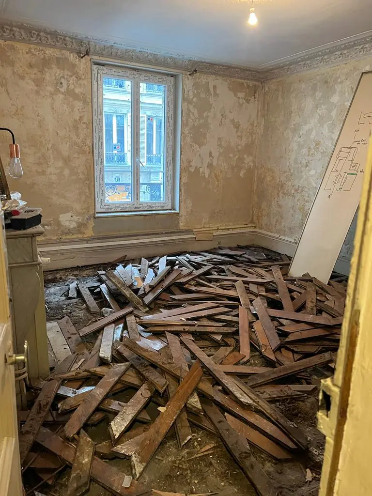 Pièce avant travaux : ancien parquet déposé et murs à reprendre