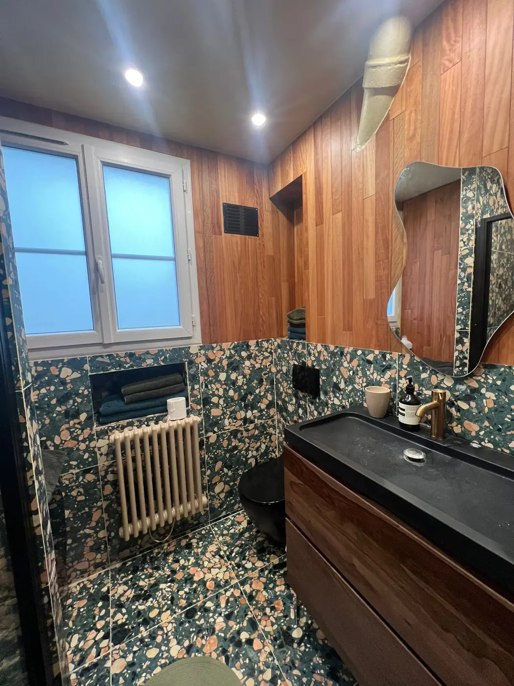 Salle d'eau terrazzo vert, bois et douche vitrée