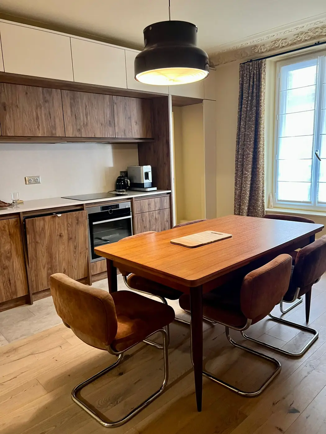 Cuisine bois et table en noyer ouverte sur la salle à manger, Paris 9e