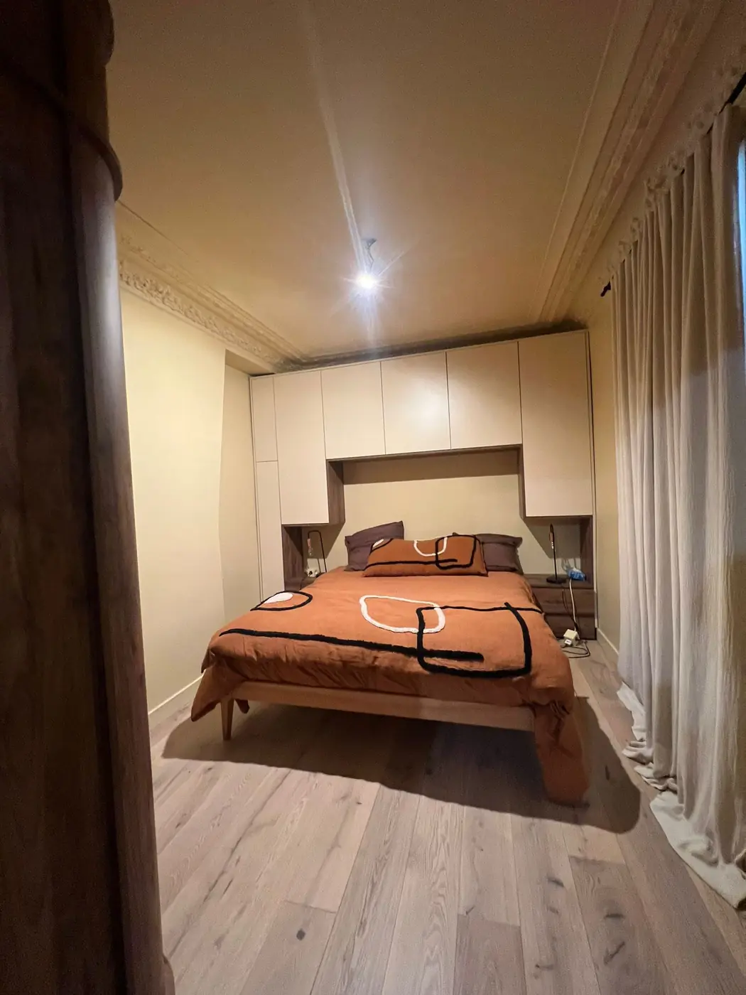 Chambre rénovée avec parquet et tête de lit