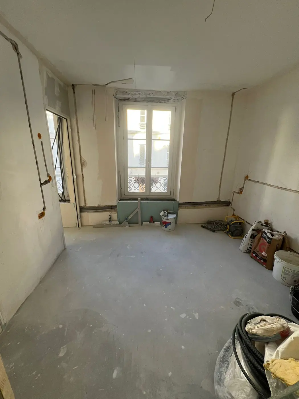 Séjour avant travaux, sols bruts et réseaux à refaire