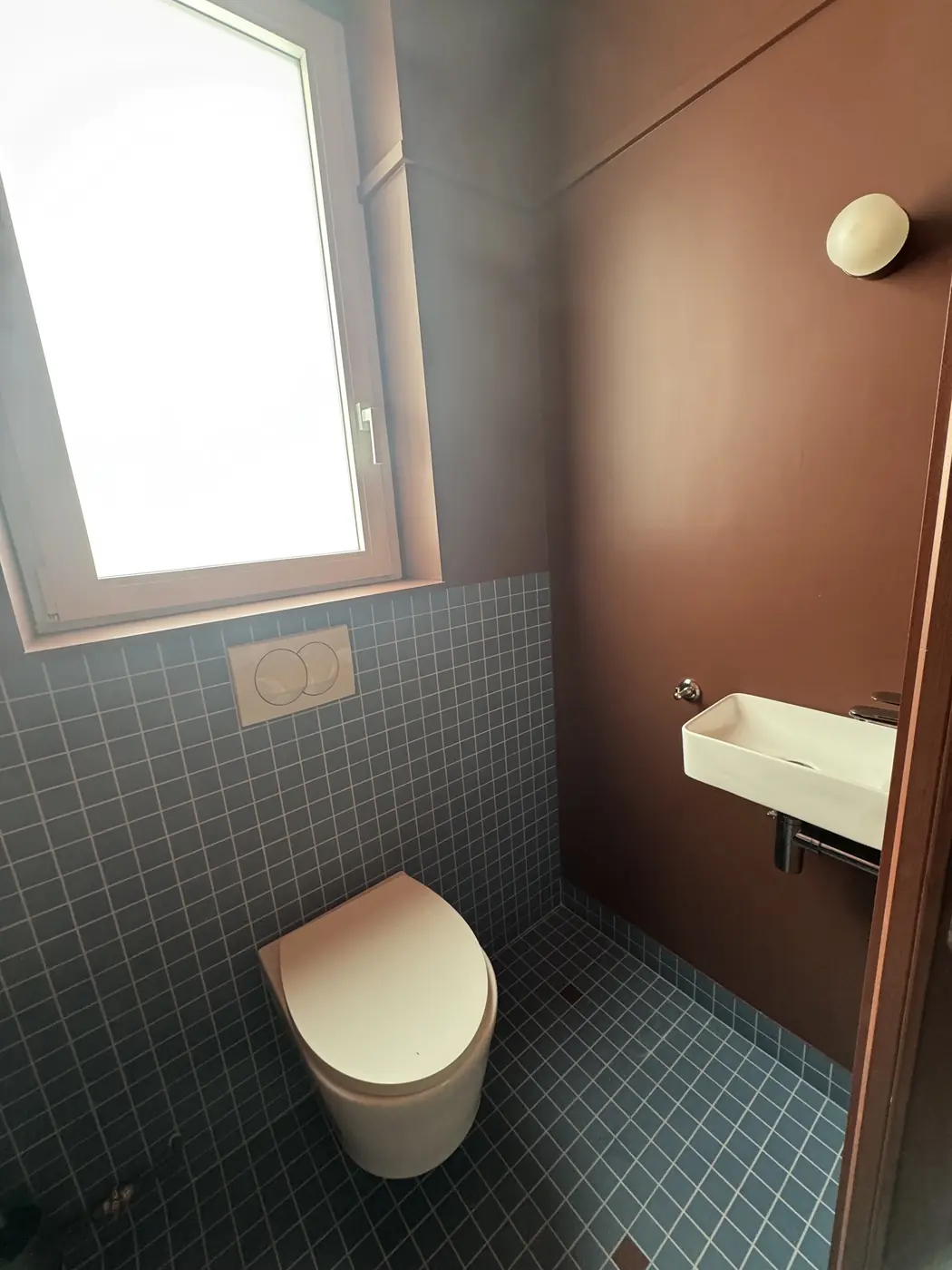 WC suspendu, mosaïque bleue et lave-mains
