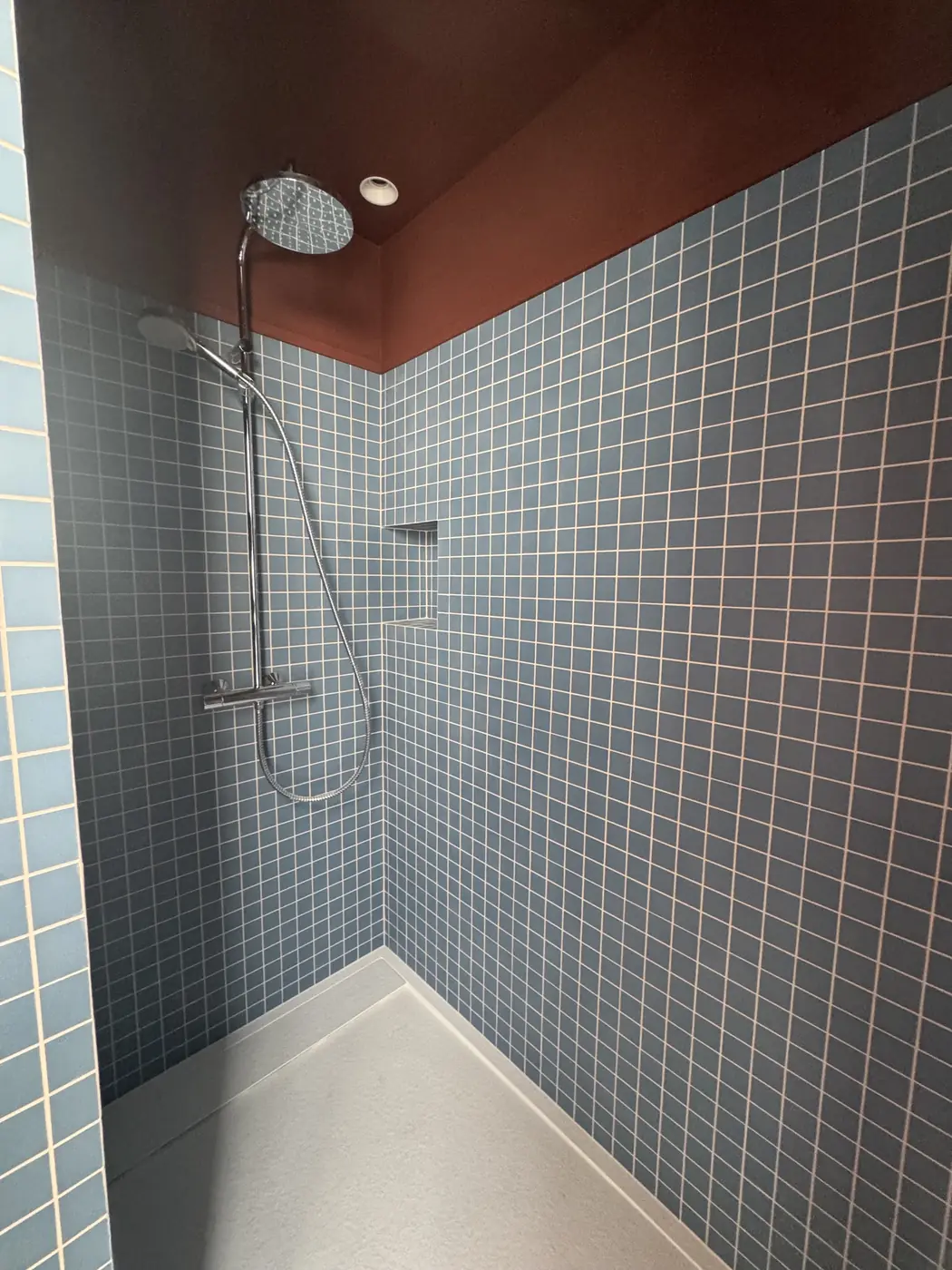 Douche à l'italienne en mosaïque bleue et plafond terracotta