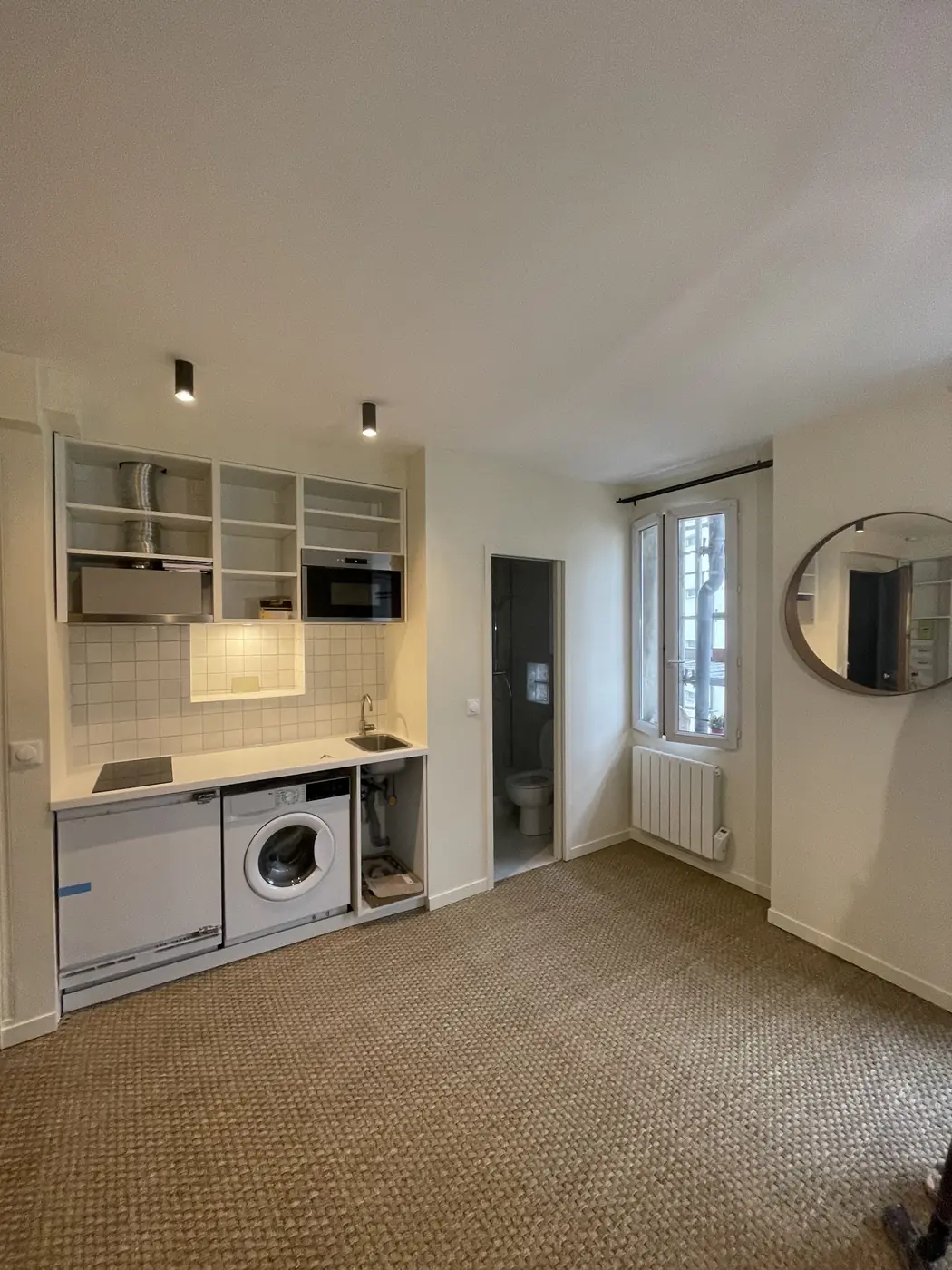Pièce de vie avec kitchenette et rangements intégrés