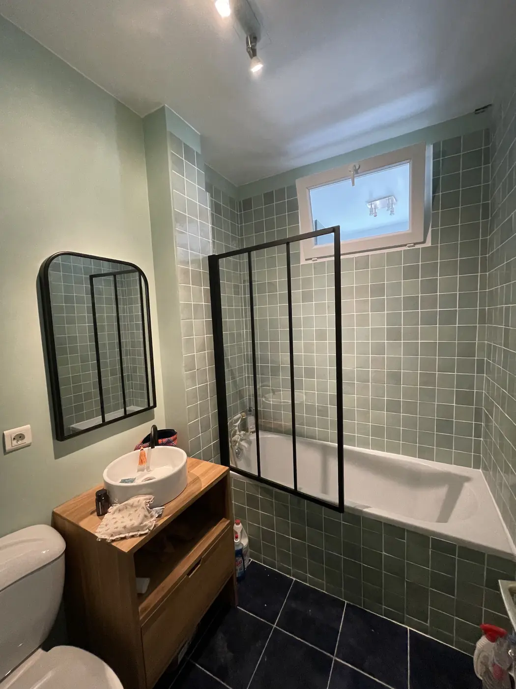 Salle de bains avec paroi type verrière et carrelage vert