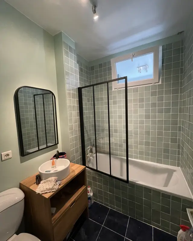 Salle de bains avec paroi type verrière et carrelage vert
