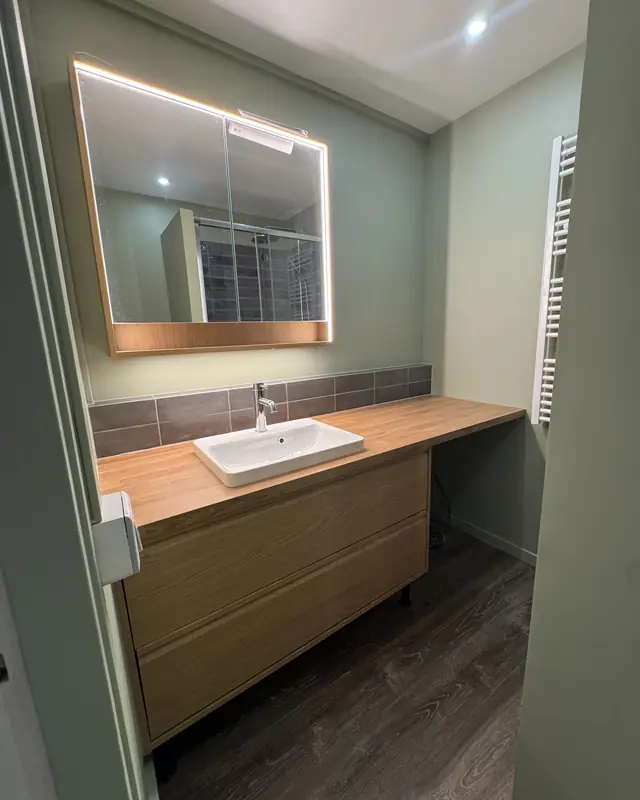 Salle de bains vert sauge, meuble vasque bois et miroir lumineux, Paris 13e