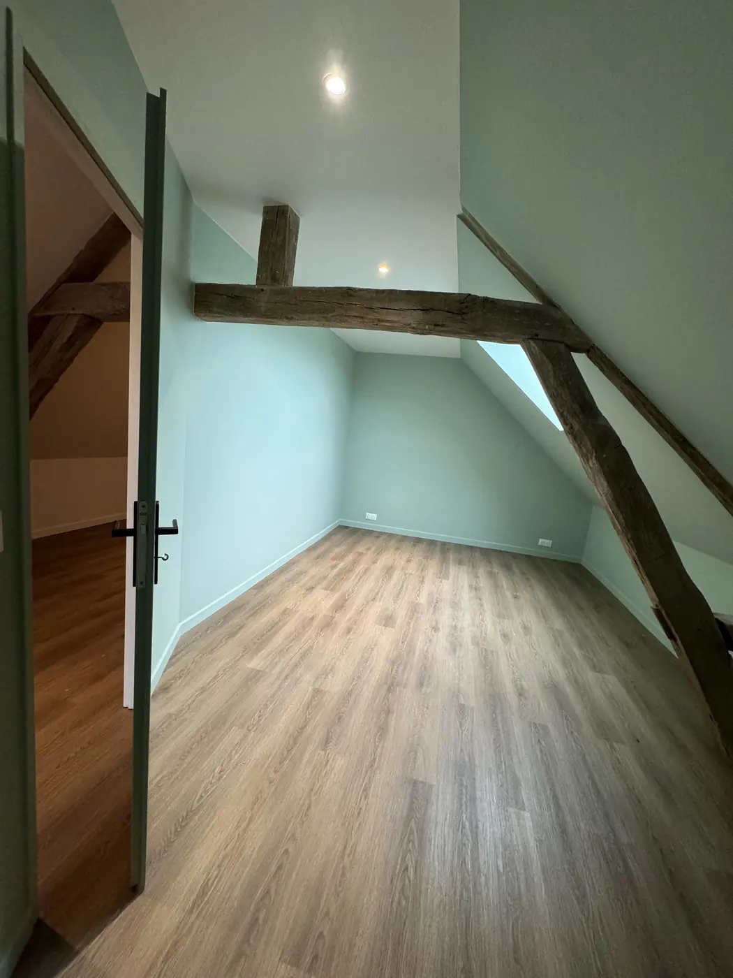 Chambre sous combles vert sauge avec poutres anciennes